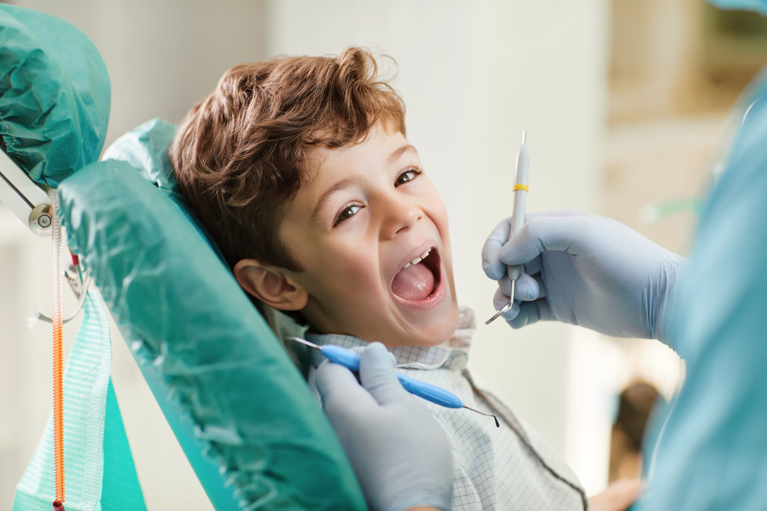 Beautiful child smiling while sitting in the dentist's chair. Close-up.