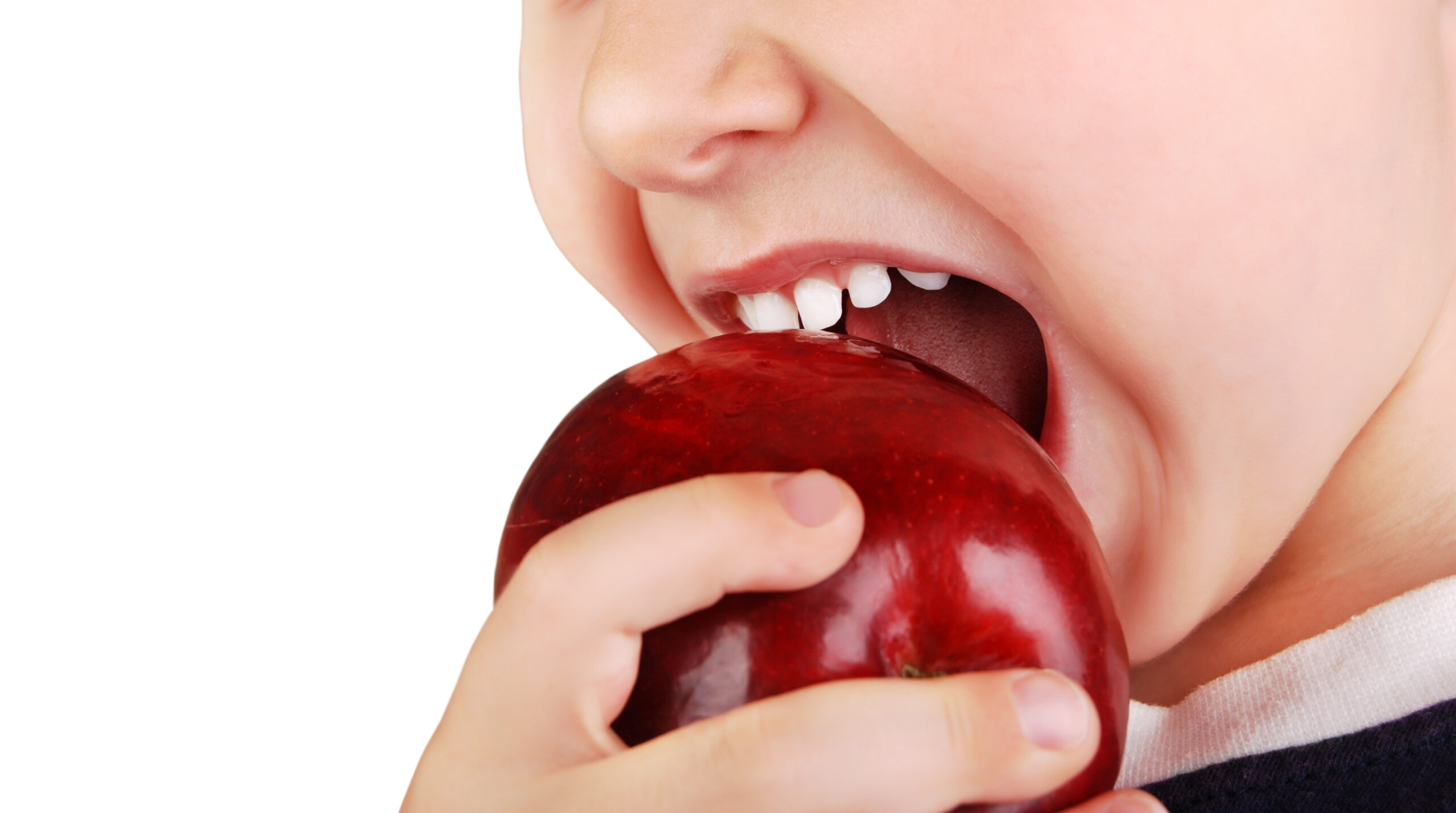Close-up view child's healhty teeth and ripe red apple