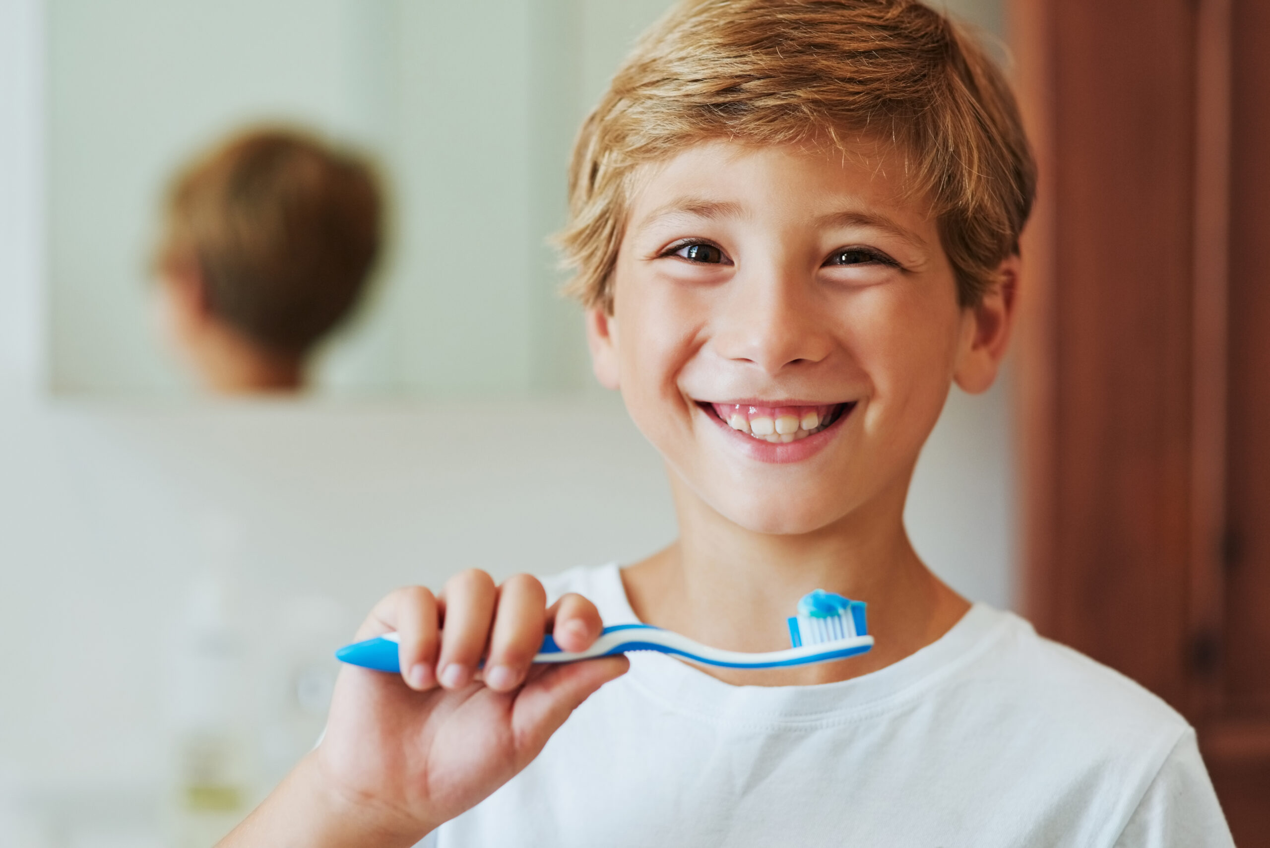 Boy child, portrait or toothbrush in bathroom for cleaning teeth, oral care or hygiene in home. Male kid, smile or whitening with toothpaste for morning routine or wellness, dental health in house.