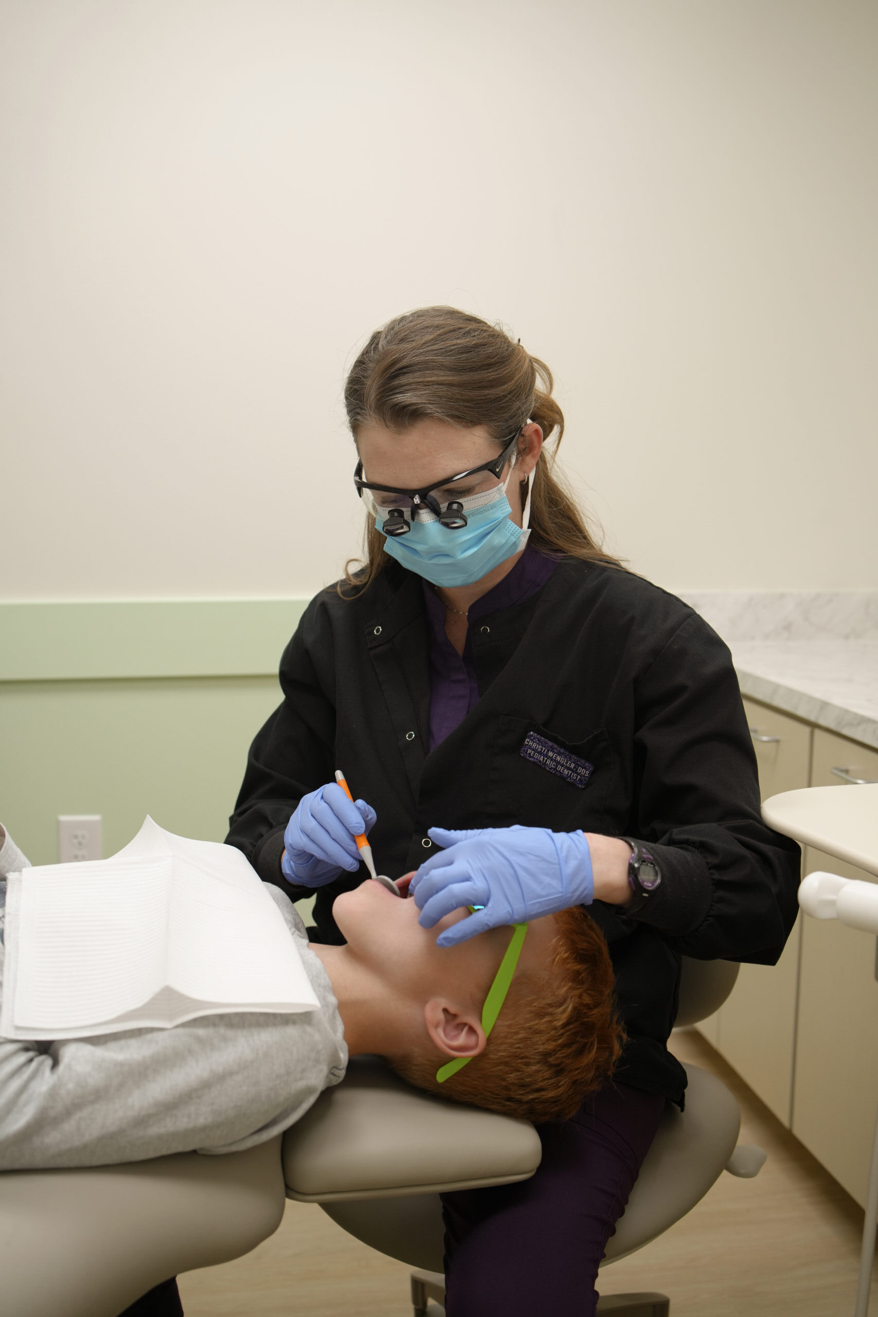 Dr. Wengler performing an oral examination on a child patient