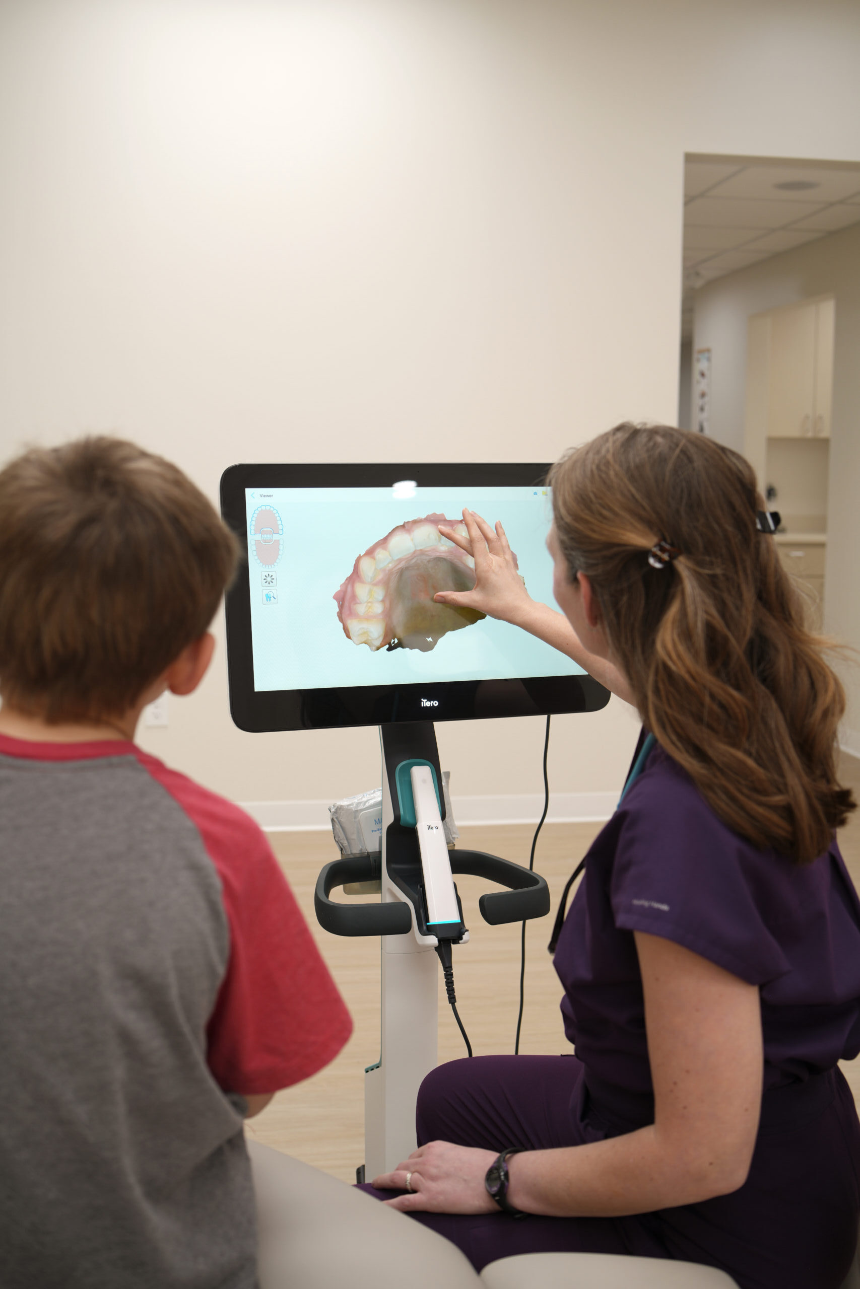 Young patient and Dr. Wengler reviewing interactive dental scan on tablet