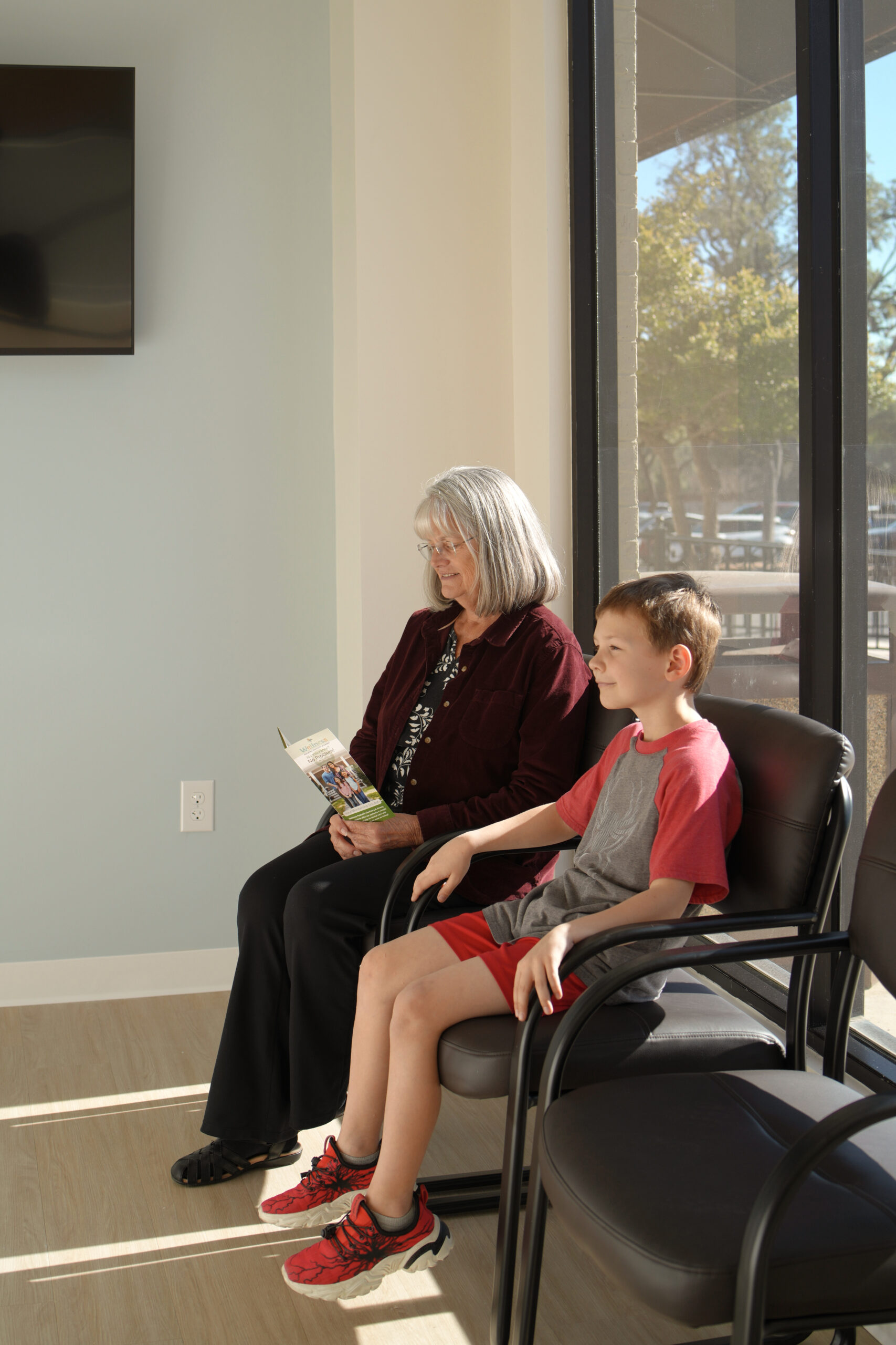 Grandmother and child reading in the bright waiting room