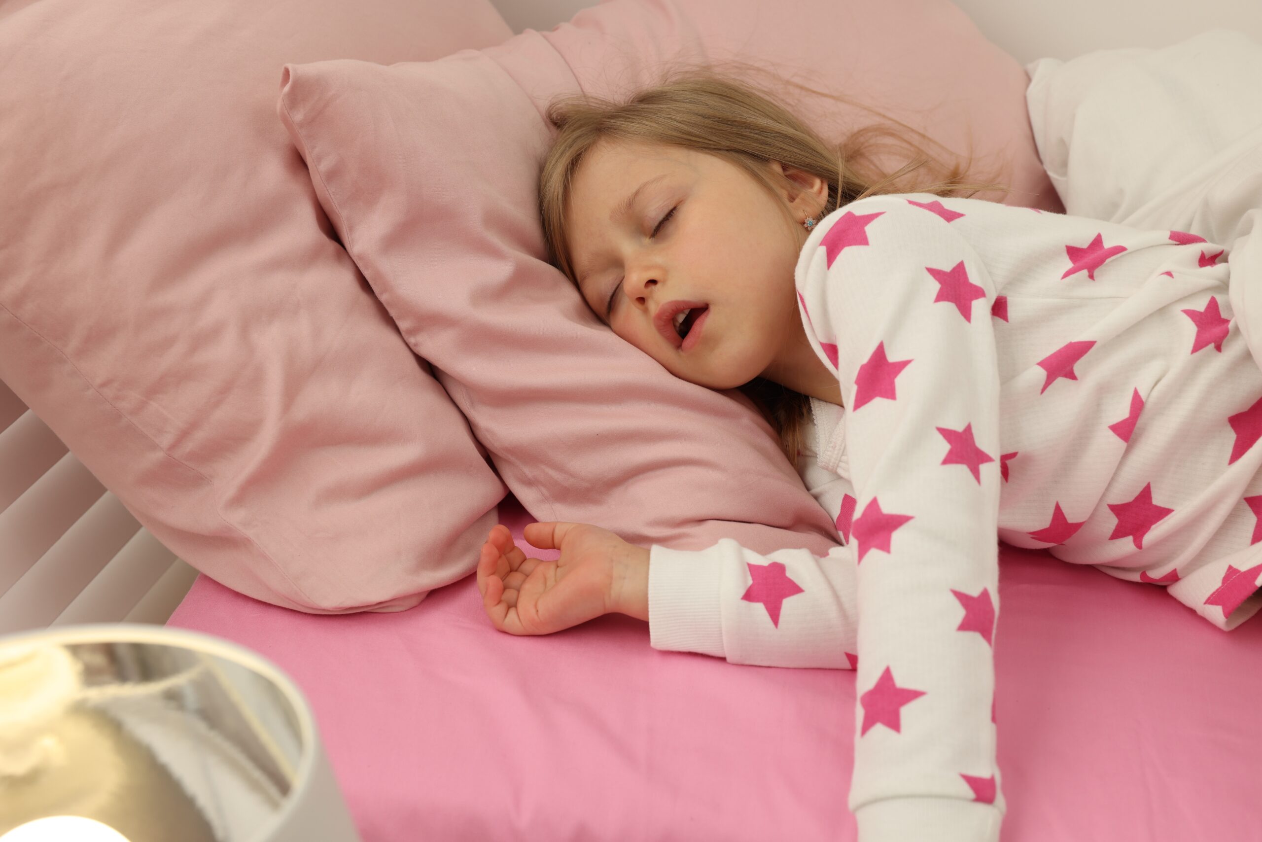 Little girl snoring while sleeping in bed