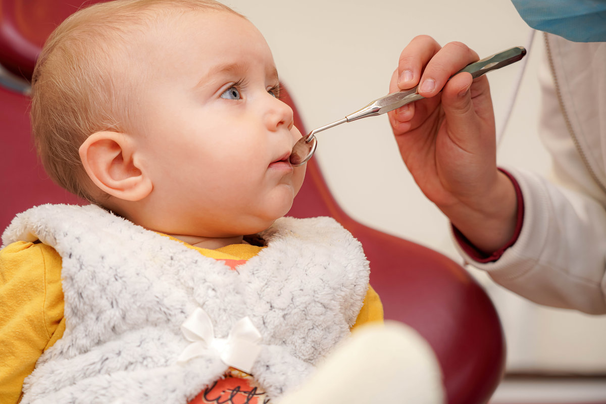 The dentist examines the child and checks the baby teeth.