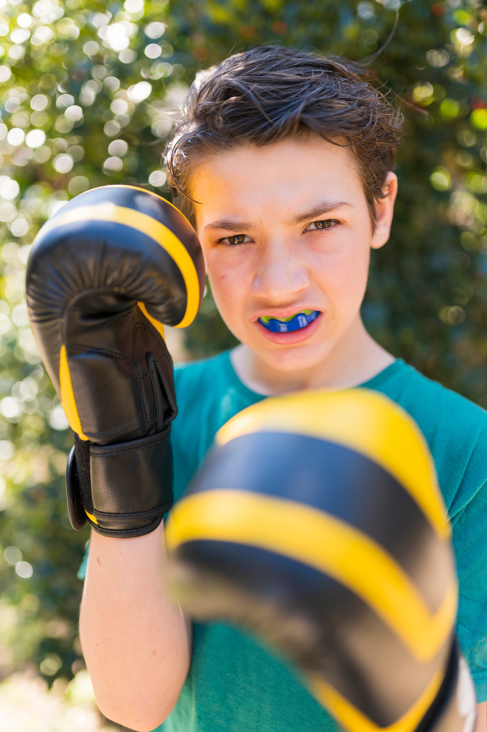 Boy practicing boxing outdoors.
